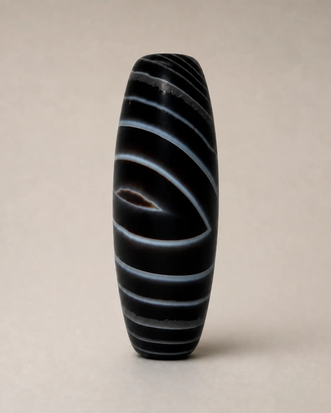 Banded Agate Dzi Bead with a dark oval centre framed by curved pale bands — approx. 40.8 × 15.1 mm | Front