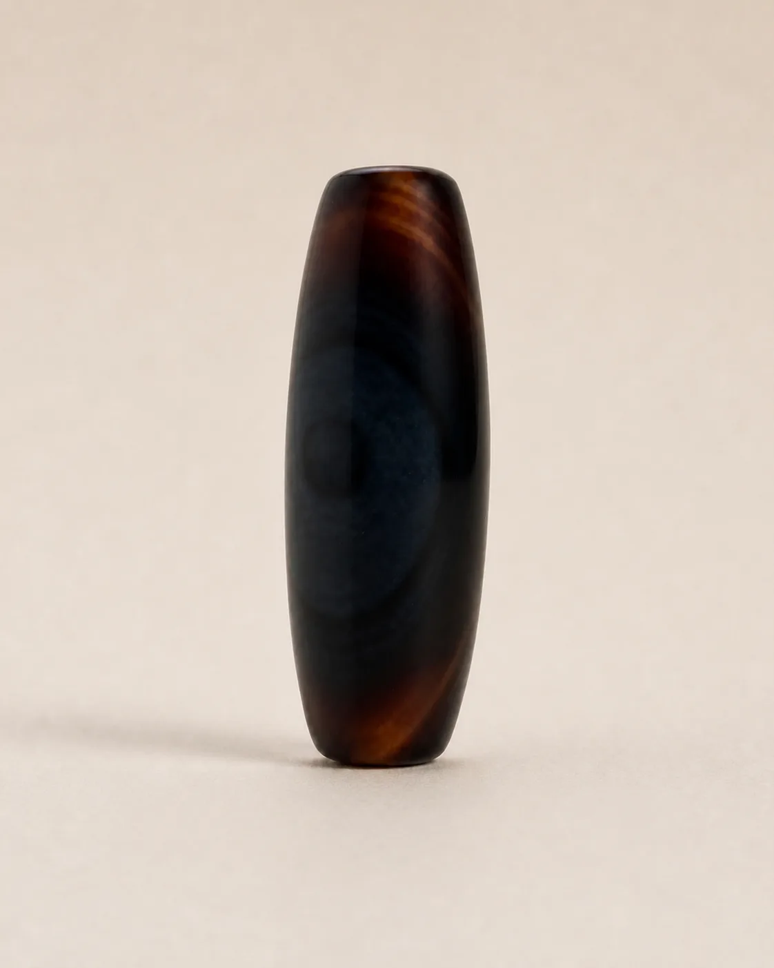 Banded Agate Dzi Bead with subtle tonal banding across a near-solid dark field — approx. 36.4 × 13.3 mm | Front