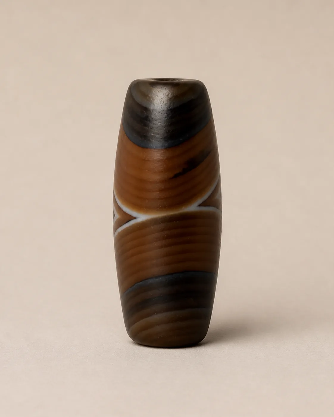 Banded Agate Dzi Bead with crossing pale curves on a warm-brown field — approx. 27.6 × 12.9 mm | Front