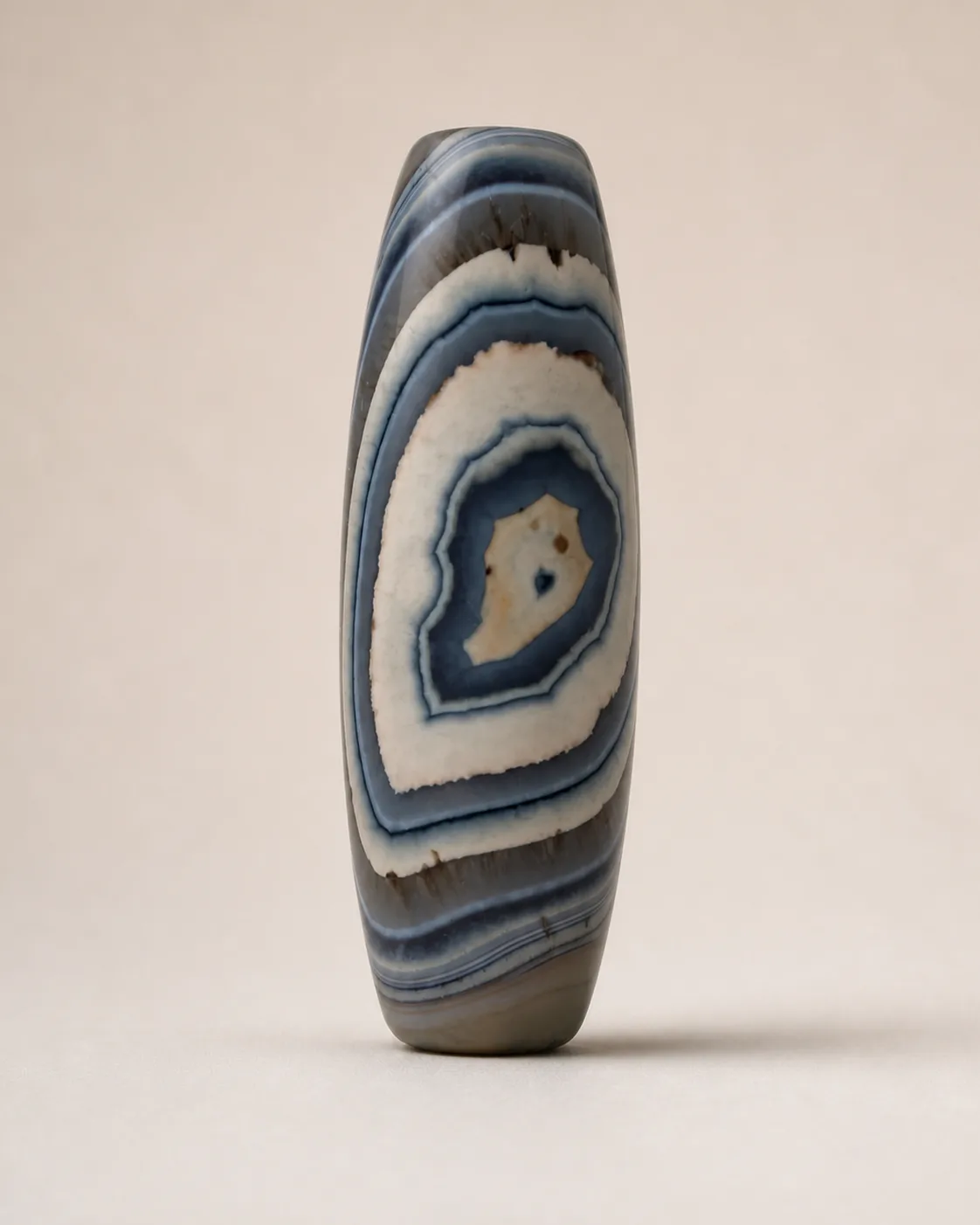 Banded Agate Dzi Bead with pale concentric oval layers around a dark centre — approx. 47.2 × 15.9 mm | Front