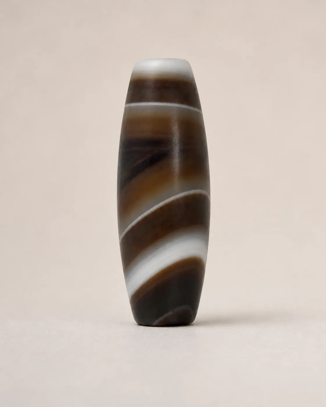 Banded Agate Dzi Bead with broad pale rings across a brown field — approx. 33.3 × 14.3 mm | Front