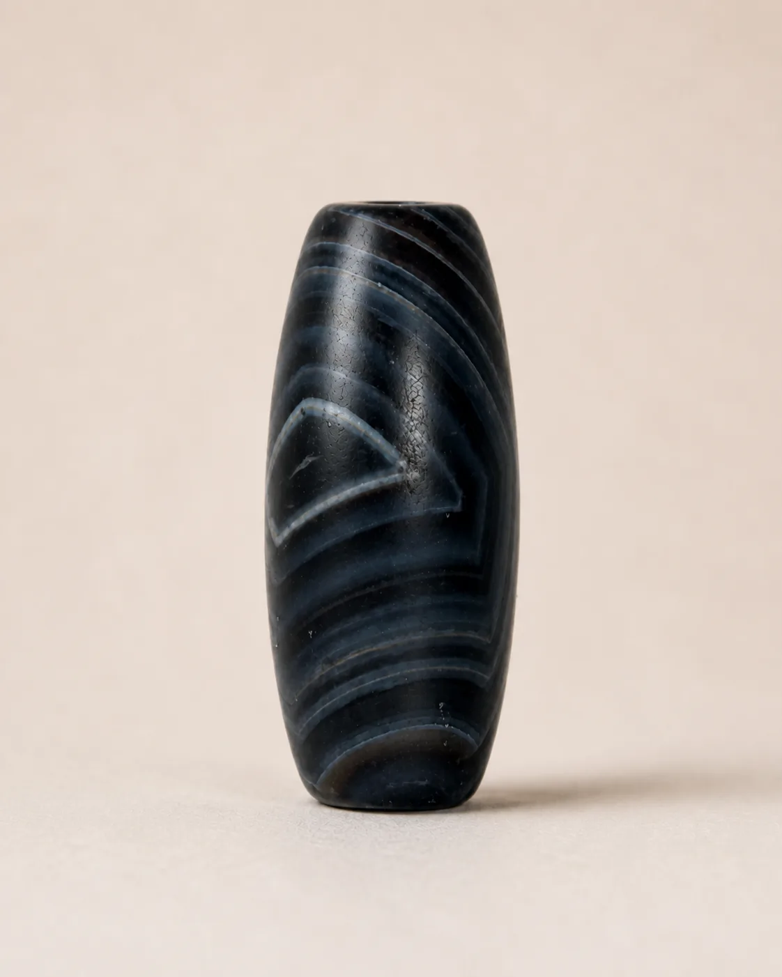 Banded Agate Dzi Bead with sweeping curved bands across a compact dark profile — approx. 28.3 × 14.3 mm | Front