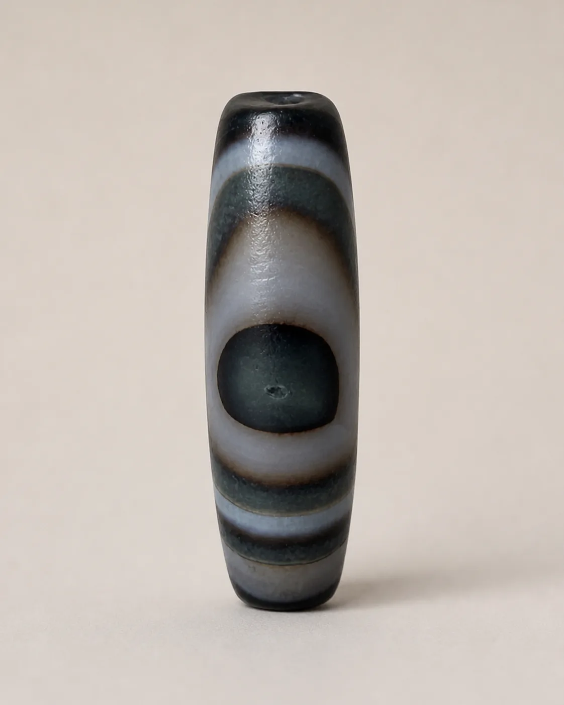 Banded Agate Dzi Bead with a broad pale ring surrounding a dark oval centre — approx. 41 × 14.7 mm | Front