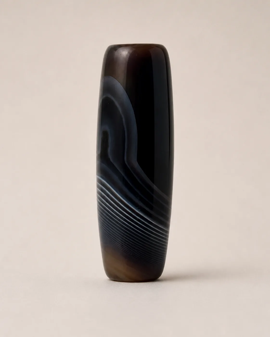Banded Agate Dzi Bead with a dark field crossed by fine diagonal bands — approx. 40.8 × 14.6 mm | Front