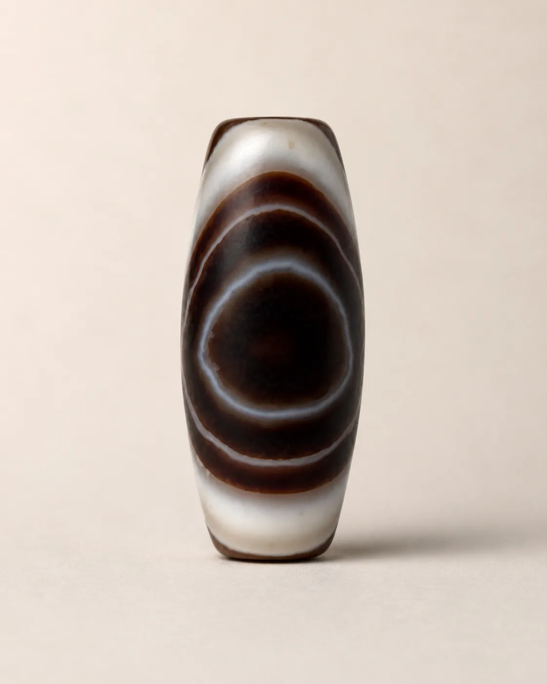Banded Agate Dzi Bead with a dark round centre with pale concentric rings — approx. 31.5 × 14.1 mm | Front