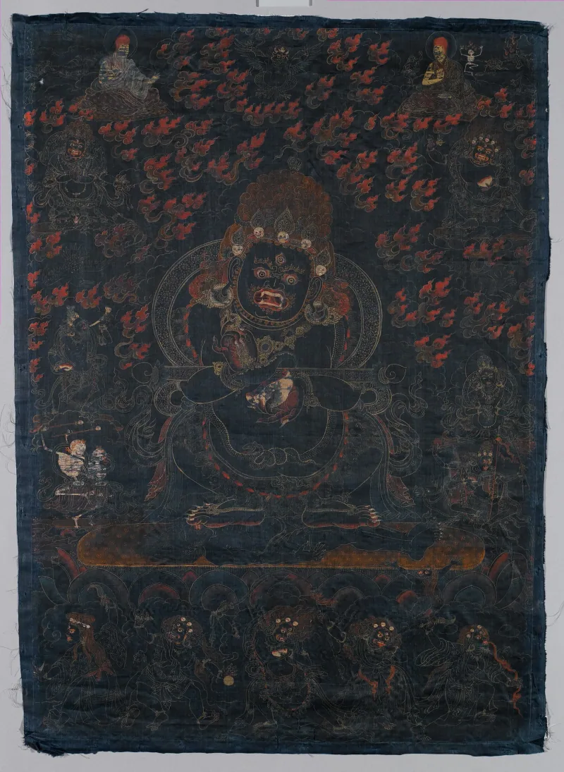 Mahakala on a dark field with fine contours, red flames and smaller surrounding figures.