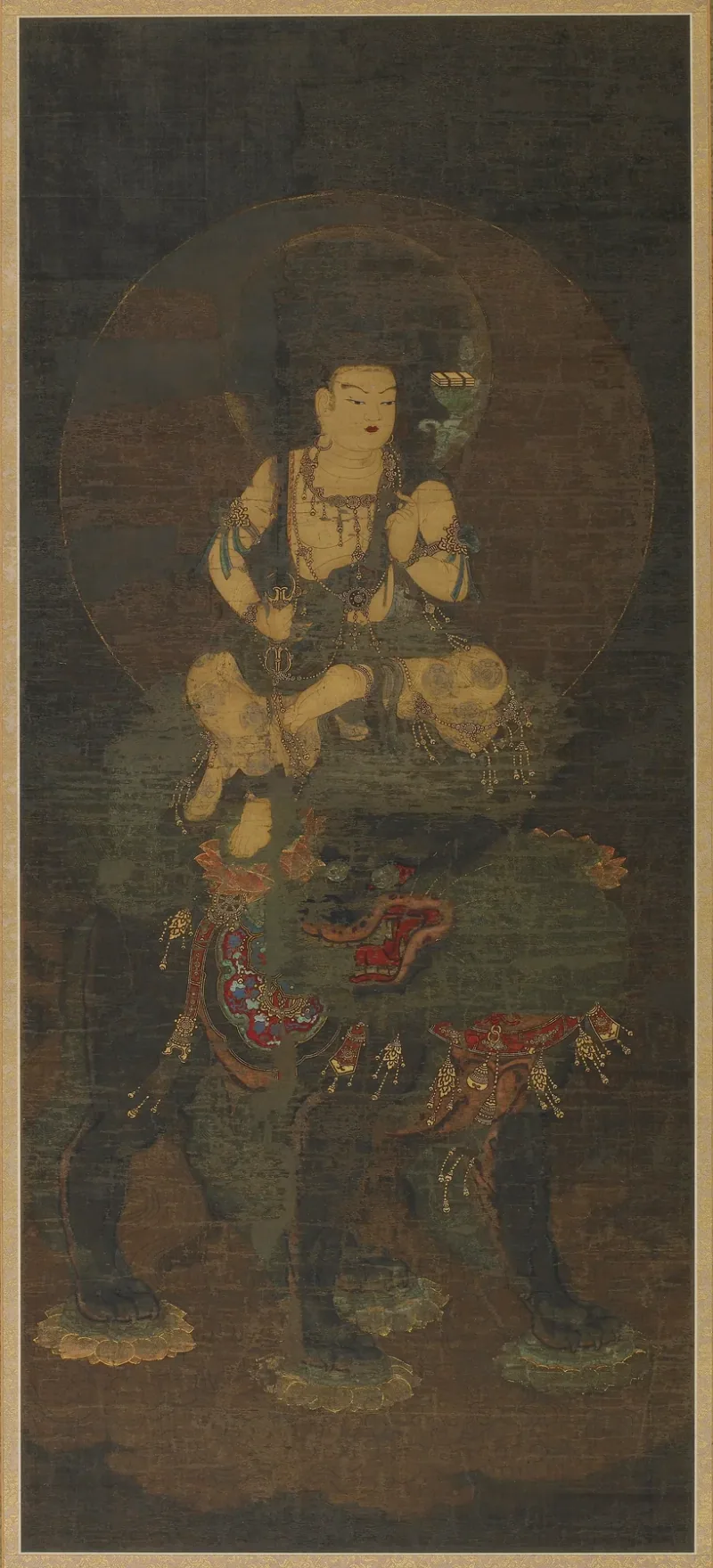 Japanese painting of Monju on a lotus above a lion, with a book and upright weapon and attendants below.