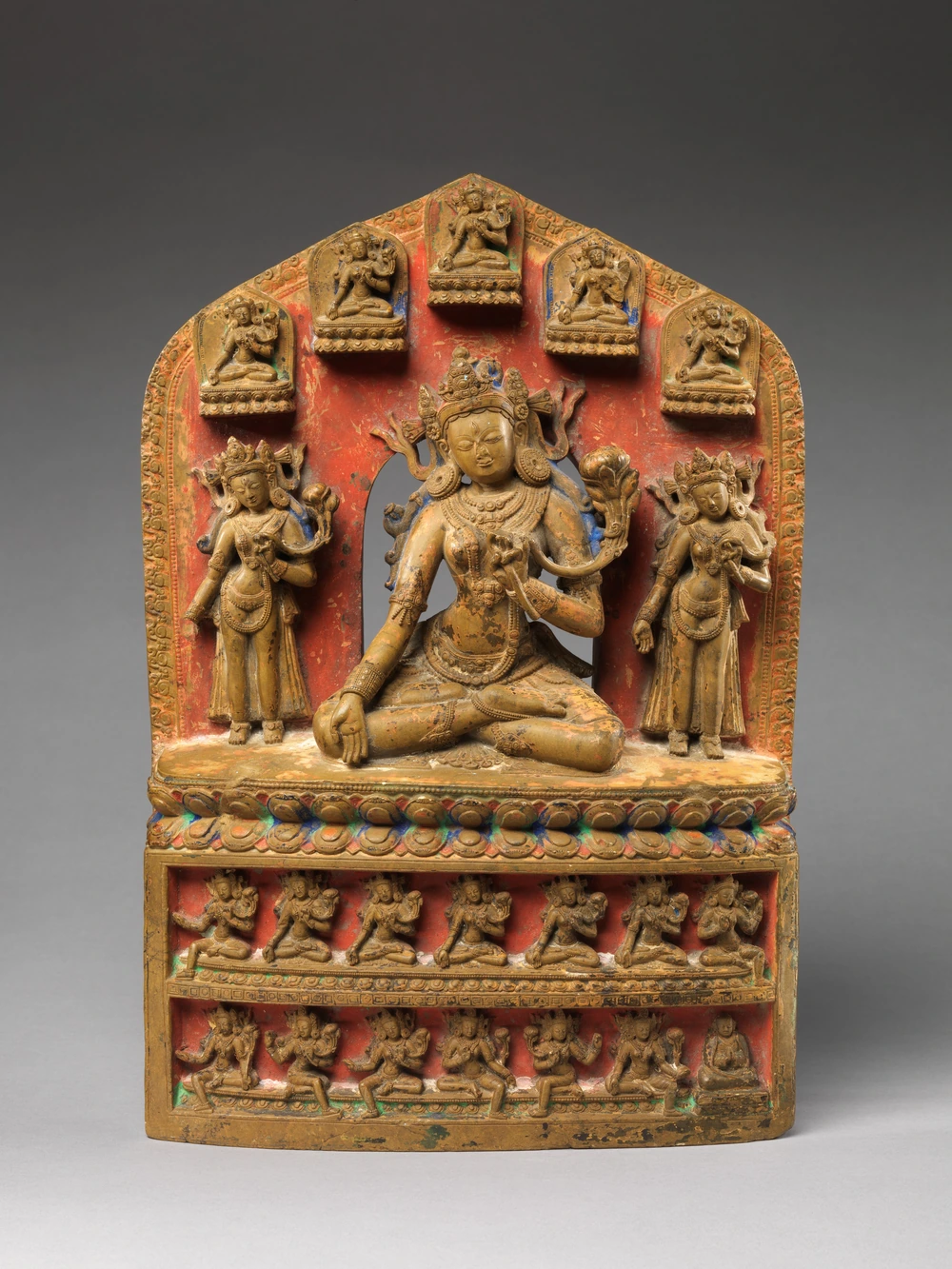 Polychrome Tibetan stone group with White Tara at centre.