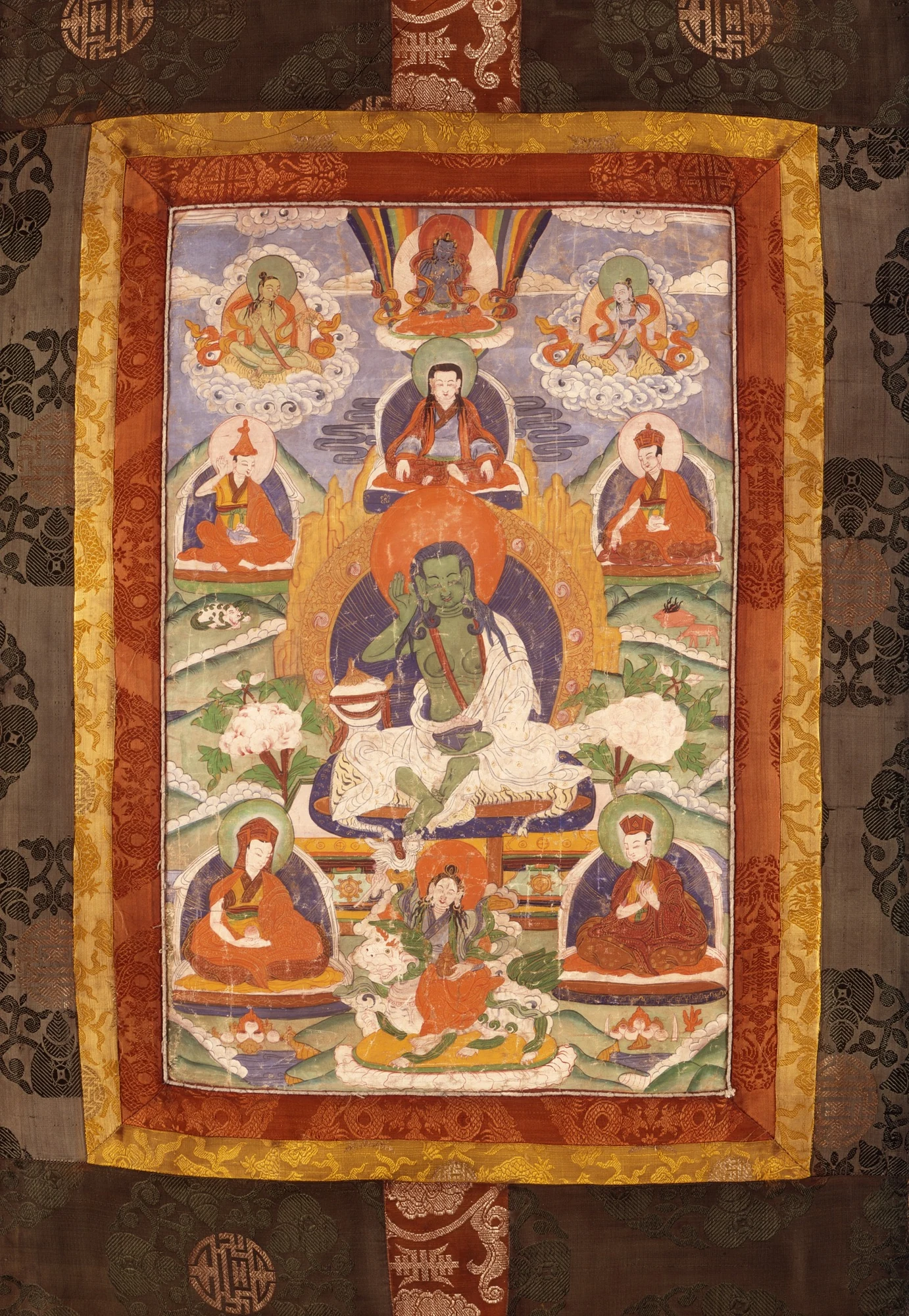 Milarepa with a raised hand, white robe and surrounding figures.