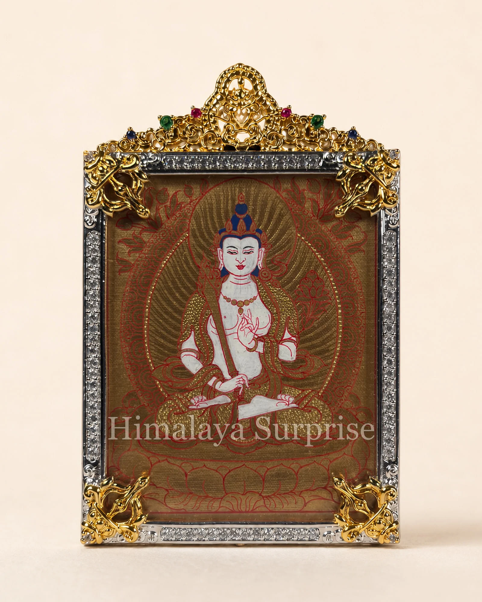 Front of a miniature thangka pendant in its ornamental housing