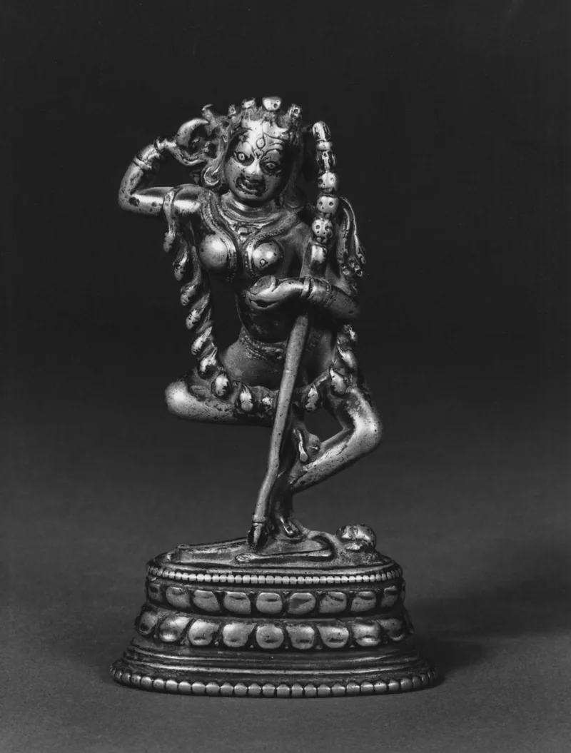 Vajravarahi dancing on a prostrate figure, with a small boar head, cup and curved knife in a twelfth-century bronze.