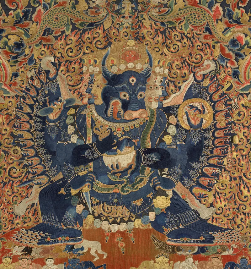 Detail of Vajrabhairava showing stitched facial features, ornaments, multiple arms and flame patterns.