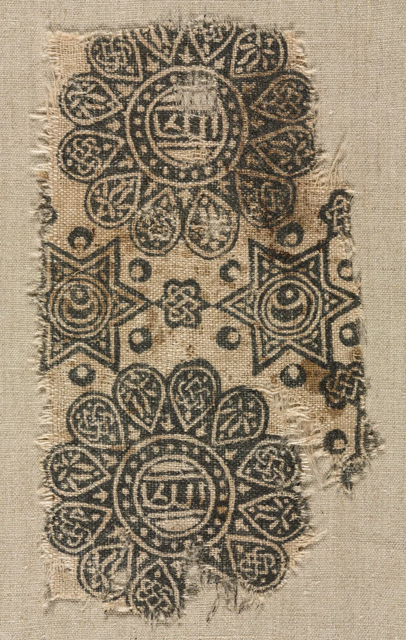 Whole Egyptian linen fragment with two printed round medallions, stars and interlocking motifs, with frayed edges retained.