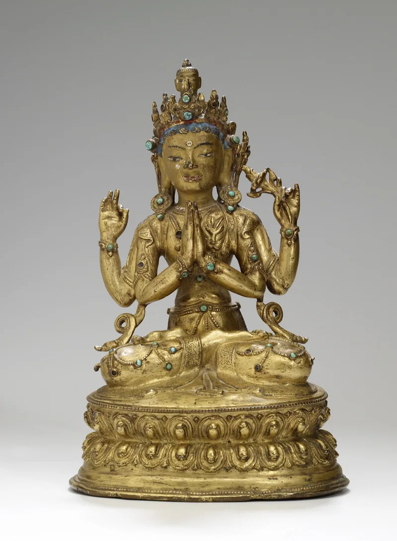 Gilded Tibetan four-armed Avalokiteshvara sculpture with palms joined at the chest, a surviving lotus, an empty rear hand and Amitabha’s head above the hair.