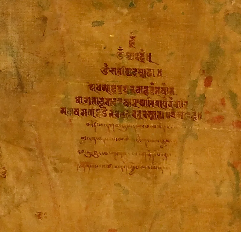 An inscription on the reverse of the early Green Tara painting, shown against the aged cloth surface.