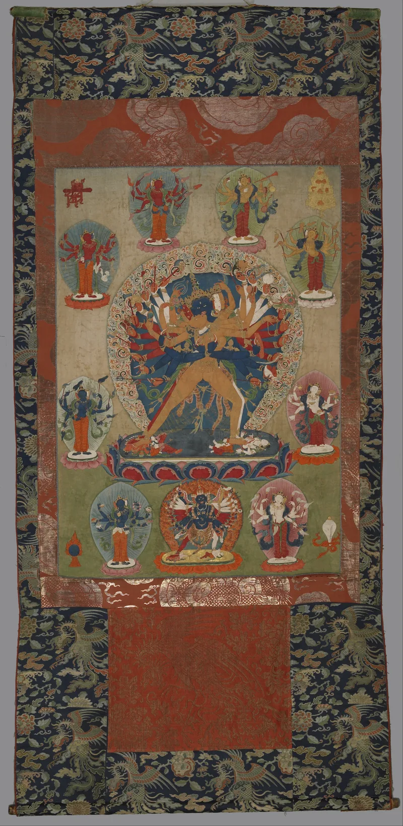 Whole mounted painting with a blue multi-armed Kalachakra and gold-coloured Vishvamata, surrounded by smaller deities.