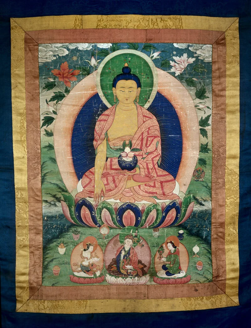 Medicine Buddha painting surrounded by reddish inner bands and a wide yellow patterned textile border.