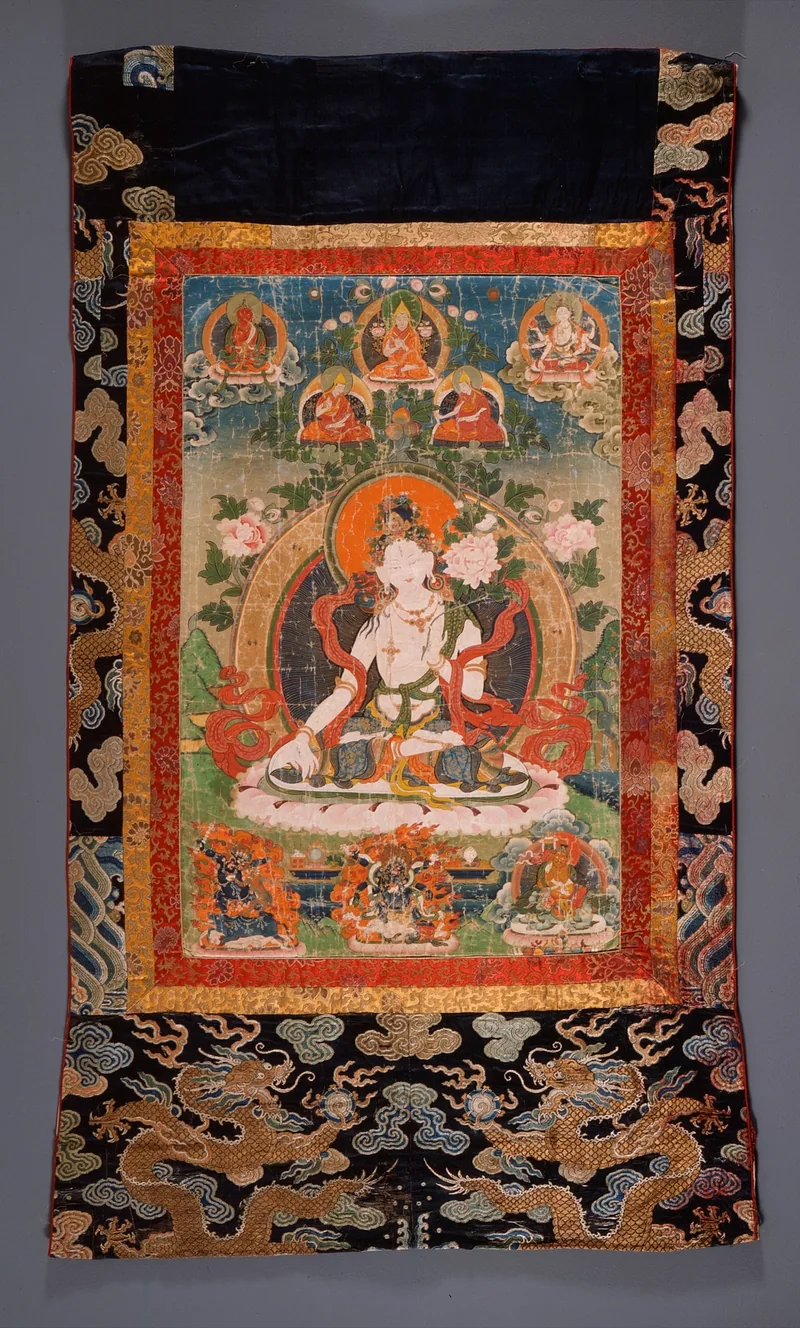 A mounted White Tara thangka with long-life deities at the upper corners, teachers above and protectors below.